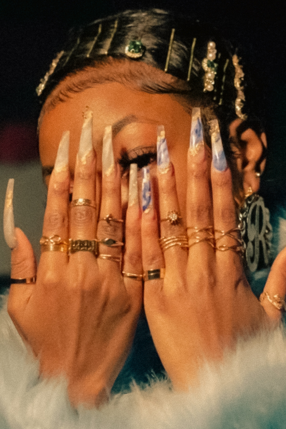 Black beauty professional with intricate nails, braids and gold jewelry